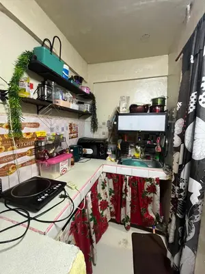a kitchen with a counter with a sink and a stove at Liza residence in Manila