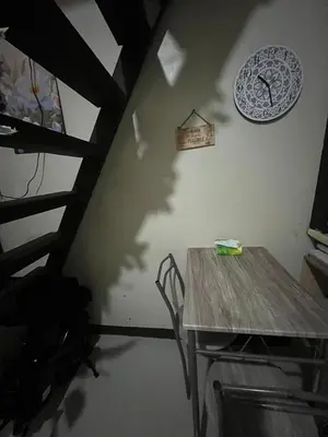 a dining room with a table and a clock on the wall at Liza residence in Manila