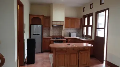 a large kitchen with wooden cabinets and a refrigerator at Happy Place Antipolo in Antipolo
