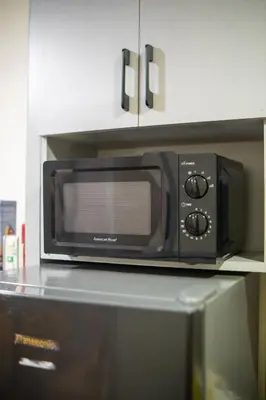 a microwave oven sitting on top of a counter at Cozy 1BR Balcony with Pool View Plus Free Parking in Manila