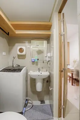 a bathroom with a sink and a toilet in a room at Cozy 1BR Balcony with Pool View Plus Free Parking in Manila