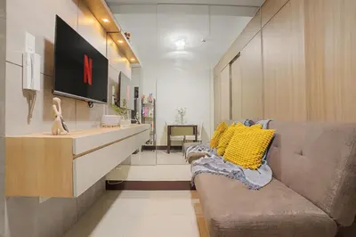 a living room with a couch and a tv at Cozy 1BR Balcony with Pool View Plus Free Parking in Manila