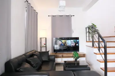 a living room with a couch and a flat screen tv at Idesia Dasmarinas NEW 3BR home with wifi & parking in Dasmariñas