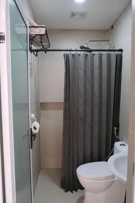 a bathroom with a shower curtain and a toilet at Idesia Dasmarinas NEW 3BR home with wifi & parking in Dasmariñas