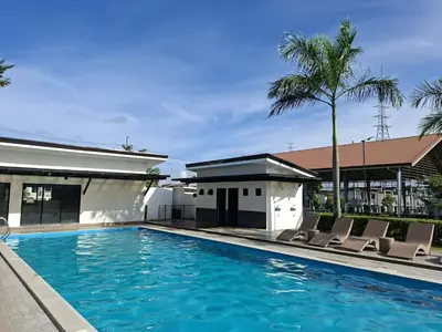 a swimming pool with chairs and a house at Idesia Dasmarinas NEW 3BR home with wifi & parking in Dasmariñas