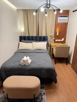 a bedroom with a large bed and a chair at AZ Sweet home 2BR A Venue Residences Poblacion Makati in Manila