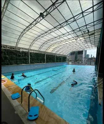 a group of people swimming in a swimming pool at AZ Sweet home 2BR A Venue Residences Poblacion Makati in Manila