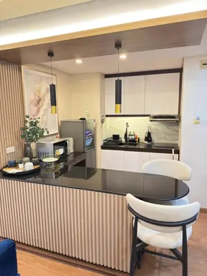 a kitchen with a counter and a table and a chair at AZ Sweet home 2BR A Venue Residences Poblacion Makati in Manila