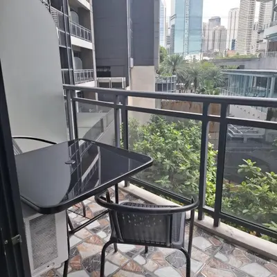 a table and chair on a balcony with a view of the city at STAYLUXIA BOUTIQUE HOTEL GRAMERCY Balcony FREE Pool, Gym, Netflix in Manila