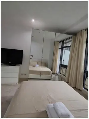 a bedroom with a mirror and a bed and a tv at STAYLUXIA BOUTIQUE HOTEL GRAMERCY Balcony FREE Pool, Gym, Netflix in Manila