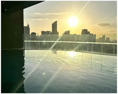 a view of a city skyline from a rooftop swimming pool at STAYLUXIA BOUTIQUE HOTEL GRAMERCY Balcony FREE Pool, Gym, Netflix in Manila