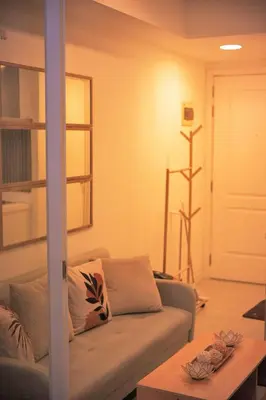 a living room with a couch and a table at Cozy Tahanan Azure Studio close to NAIA in Manila