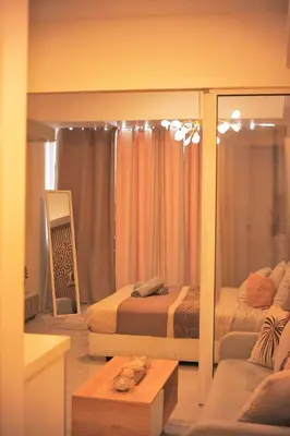 a room with two beds and a couch and a mirror at Cozy Tahanan Azure Studio close to NAIA in Manila