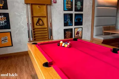 a pool table in a room with a red blanket at Modern Condo at Park McKinley West with Wi-Fi and Washer in Manila