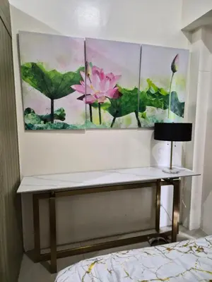 a desk in a bedroom with three paintings on the wall at Zen 2 Shore A Residences in Manila