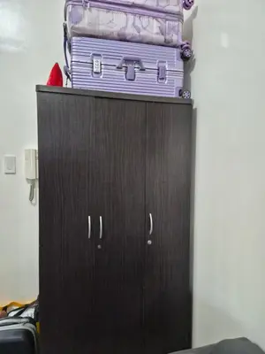 a cabinet with a stack of suitcases on top of it at Zen 2 Shore A Residences in Manila