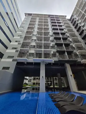 a large building with a swimming pool in front of it at Chic Urban Escape at S Residence Tower 3 in Manila