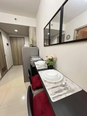 a table with plates on it in a kitchen at Chic Urban Escape at S Residence Tower 3 in Manila
