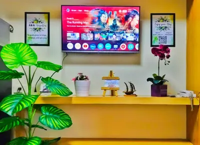 a tv on a wall with plants on a shelf at JandG MOA Staycation Amenity view at Shell residence in Manila