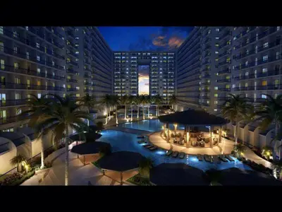 an aerial view of a large building with palm trees and umbrellas at JandG MOA Staycation Amenity view at Shell residence in Manila