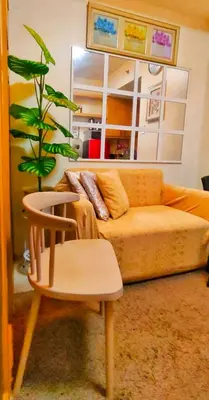 a living room with a couch and a chair and a plant at JandG MOA Staycation Amenity view at Shell residence in Manila