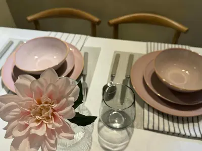 a table with two plates and a flower on it at Dusk Suites elevated escapes at Shell Residences, Mall of Asia Complex in Manila