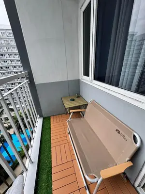 a balcony with a bench next to a window at Dusk Suites elevated escapes at Shell Residences, Mall of Asia Complex in Manila