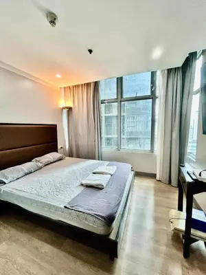 a bedroom with a large bed and a window at Prime Makati Condo Near Poblacion & Malls in Manila
