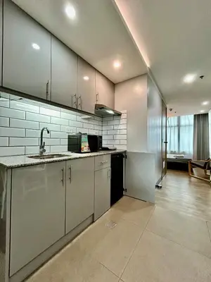 a large kitchen with white cabinets and a sink at Prime Makati Condo Near Poblacion & Malls in Manila