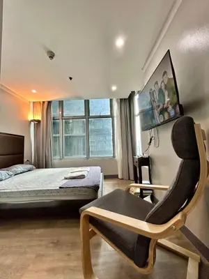 a bedroom with a bed and a chair at Prime Makati Condo Near Poblacion & Malls in Manila