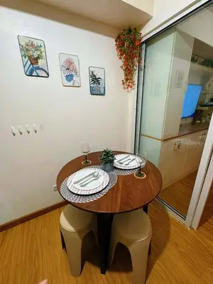 a wooden table with two plates on it in a room at The Warm Suite By ANC at Azure in Manila
