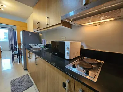 a kitchen with a microwave and a stove top oven at Shell MOA Facing View 1BR near Ikea, NAIA, PICC Shell003 in Manila