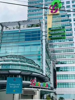 a tall glass building with a sign on it at Minimalist 1BR Condo at Araneta City, Cubao in Manila