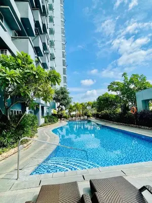 a swimming pool in front of a building at Minimalist 1BR Condo at Araneta City, Cubao in Manila