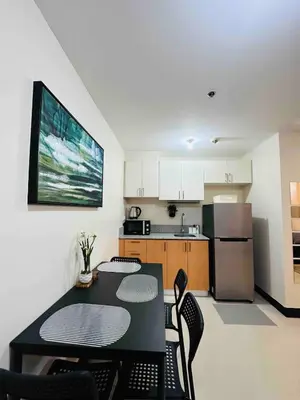 a kitchen with a table and chairs in a room at Minimalist 1BR Condo at Araneta City, Cubao in Manila