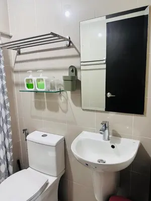 a bathroom with a white toilet and a sink at Minimalist 1BR Condo at Araneta City, Cubao in Manila