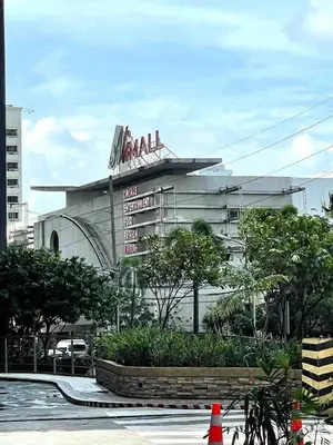 a large building with a sign on top of it at Minimalist 1BR Condo at Araneta City, Cubao in Manila