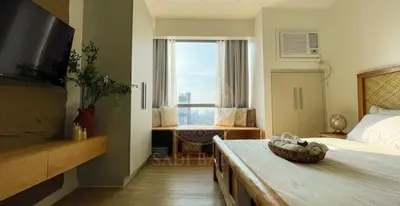 a bedroom with a bed and a large window at 3 min to Rockwell City View Pool Parking in Manila