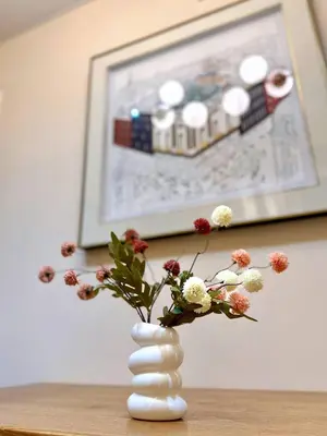 a white vase with flowers in it on a table at Azure Urban Resort 1BR-2BR St Tropez in Manila