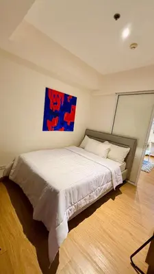 a bedroom with a bed with a painting on the wall at Azure Urban Resort 1BR-2BR Boracay in Manila