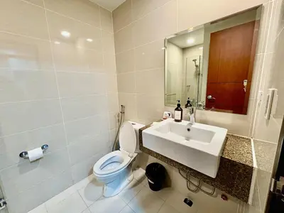 a bathroom with a toilet and a sink at 1BR at One Uptown Residence BGC Across Uptown Mall in Manila