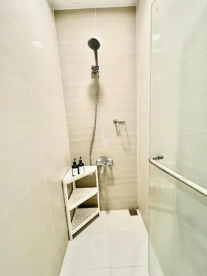 a small bathroom with a shower and a sink at 1BR at One Uptown Residence BGC Across Uptown Mall in Manila
