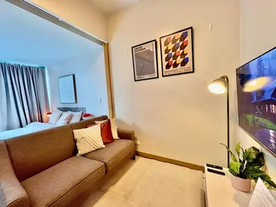 a living room with a couch and a bed at 1BR at One Uptown Residence BGC Across Uptown Mall in Manila