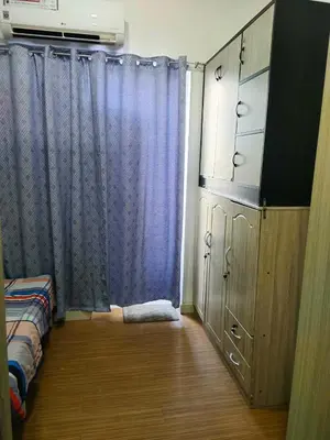 a bedroom with a blue curtain and a bed at Aureascondo in Manila
