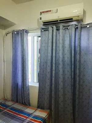 a room with blue curtains and a window at Aureascondo in Manila