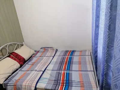a bed with a plaid comforter in a room at Aureascondo in Manila