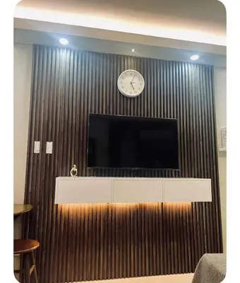 a wall with a tv and a clock on it at Staycay at SRESIDENCES in Manila