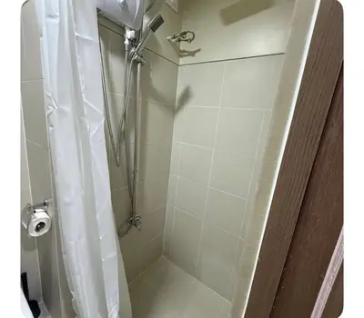a bathroom with a shower with a shower curtain at Staycay at SRESIDENCES in Manila