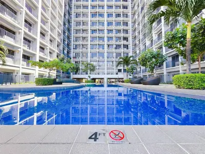 a swimming pool in front of a large building at Manila bay view Shore2 Two bedrooms in Manila