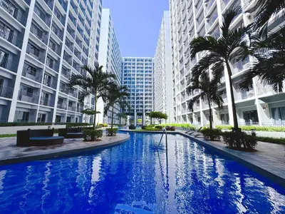 a large swimming pool in a city with tall buildings at Manila bay view Shore2 Two bedrooms in Manila